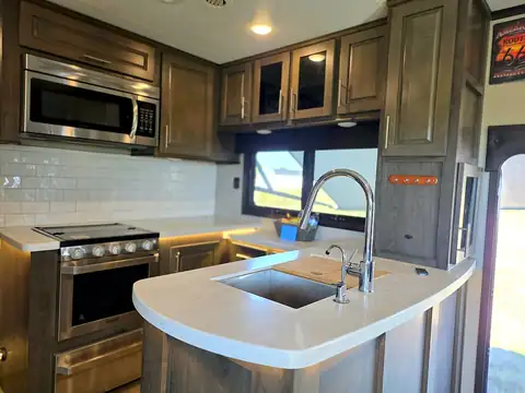 Kitchen island with sink, stove, and oven in the RV