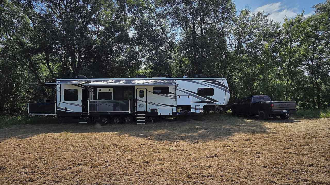 2020 Jayco Seismic 4113 toy hauler RV hitched to a tow truck, set up outdoors with ramp patio extended