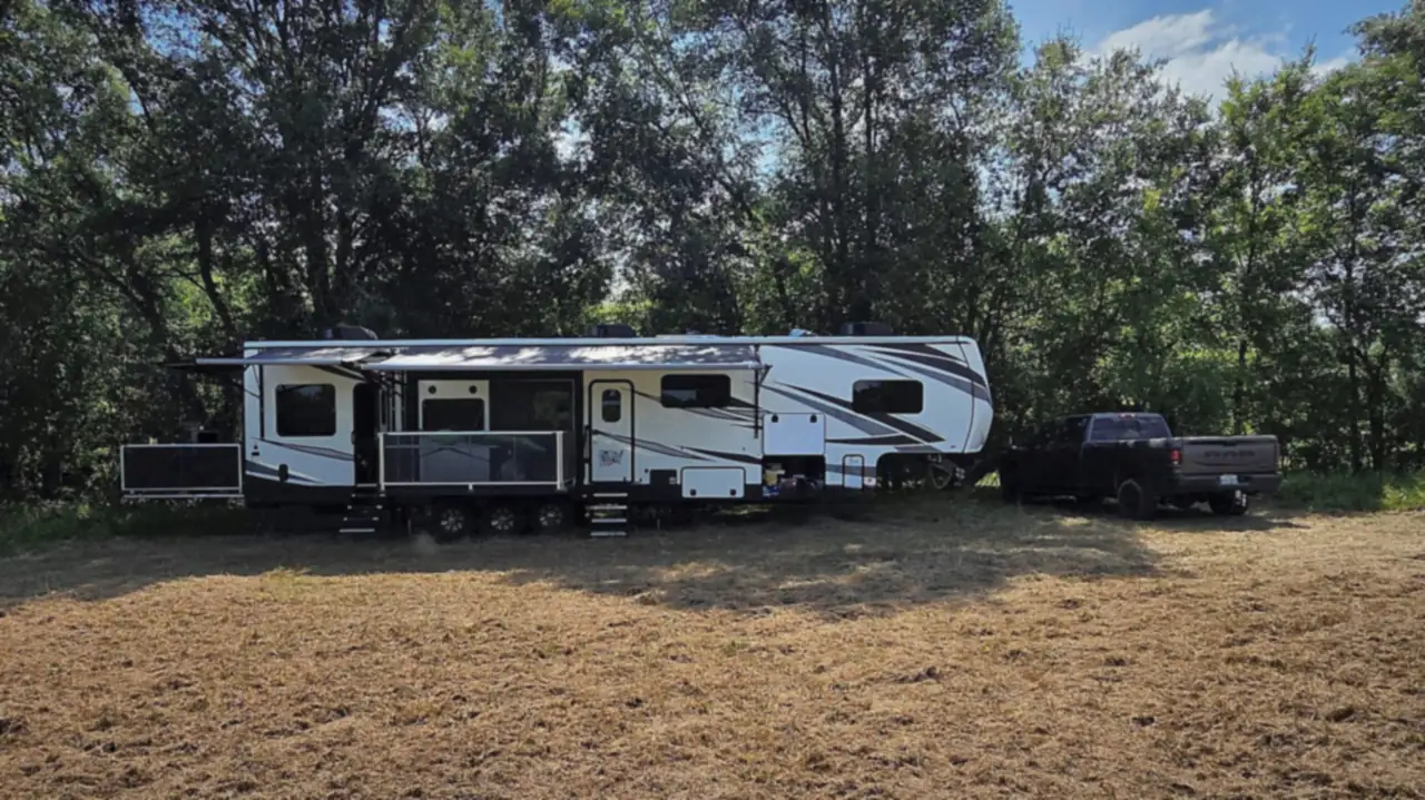 2020 Jayco Seismic 4113 toy hauler RV hitched to a tow truck, set up outdoors with ramp patio extended